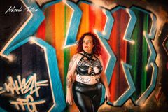 Mistress standing in front of a Grafitti wall